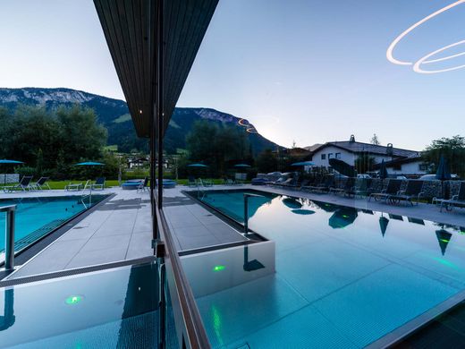 Kurzurlaub am Wilden Kaiser: Auszeit im Hotel Postwirt in Söll Moderner Außenpool mit Bergblick und Liegestühlen bei Sonnenuntergang