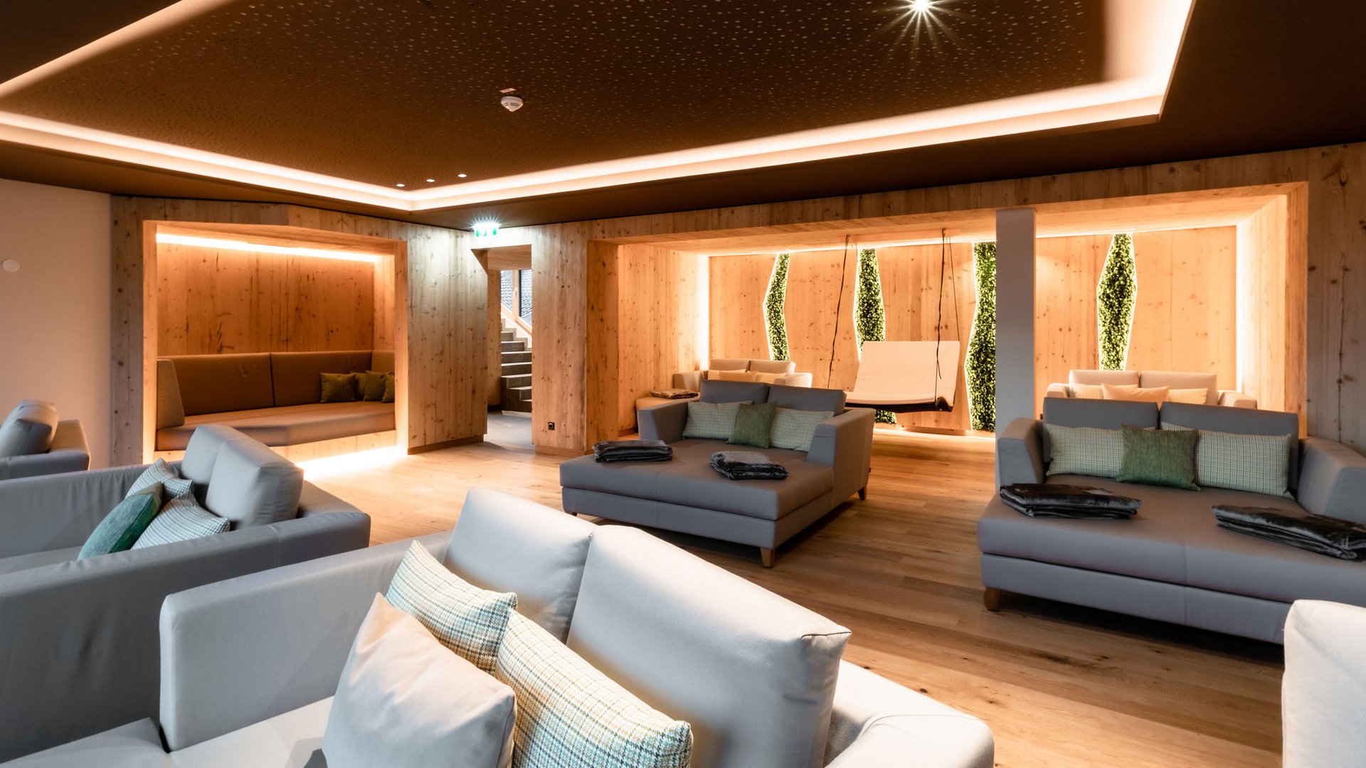 Holidays at the Postwirt: more than just in “a” hotel in Soll. Modern relaxation room with sofas, wooden walls, and soft lighting