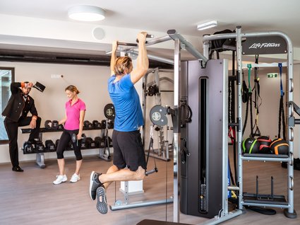 Sie suchen ein Hotel mit Fitnessstudio in Österreich? Menschen trainieren mit Fitnessgeräten in einem modernen Fitnessstudio