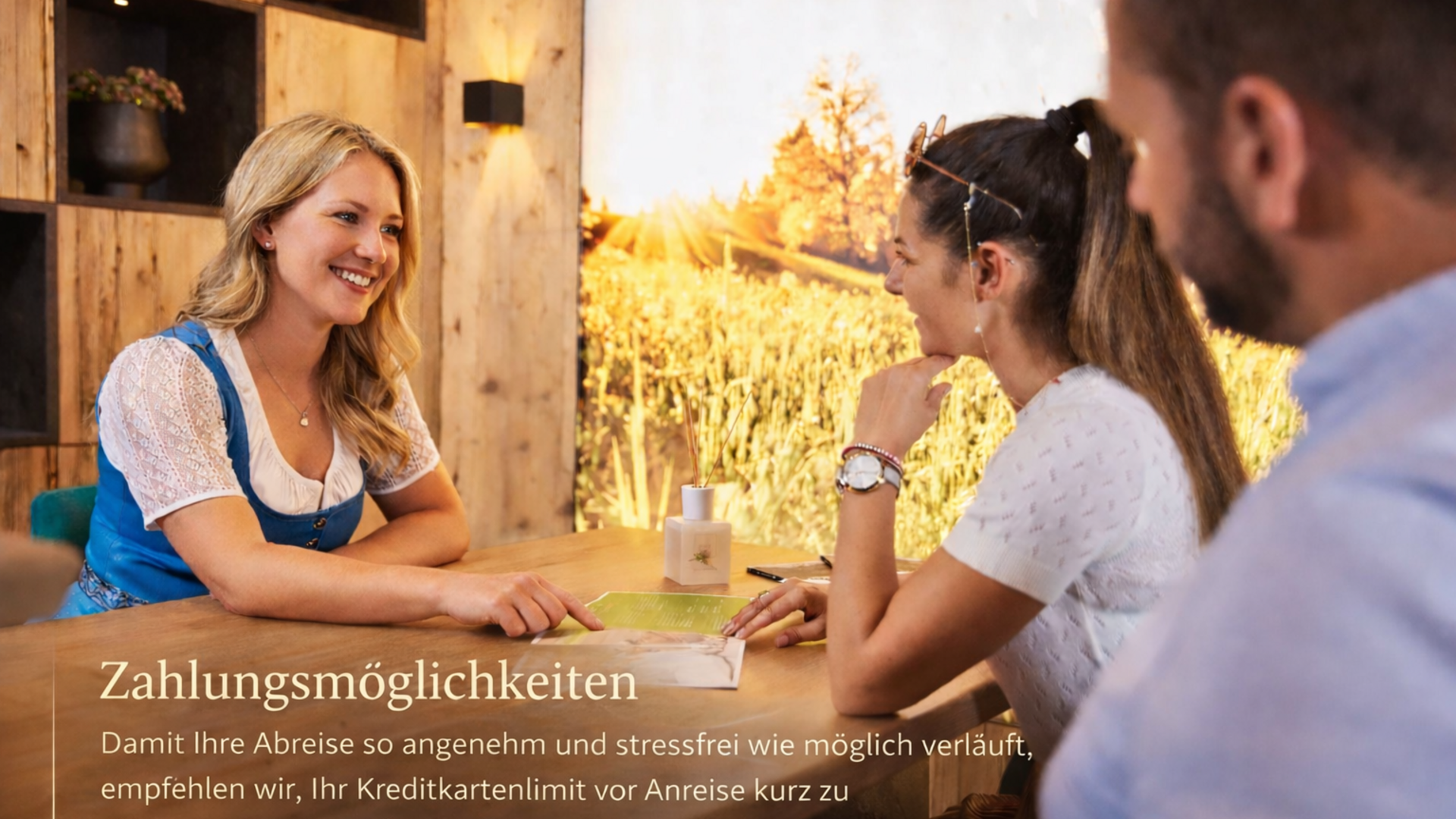 Hotel in Söll am Wilden Kaiser: der Postwirt Drei Personen beraten sich freundlich am Holztisch in hellem, gemütlichem Raum