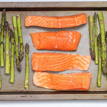 Holiday in Soll with children or as a couple Salmon fillets and green asparagus on baking tray before cooking