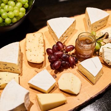 Urlaub in Söll mit Kindern oder als Pärchen Verschiedene Käsesorten mit rohen Trauben und Quitten-Apfel-Gelee auf Holzbrett