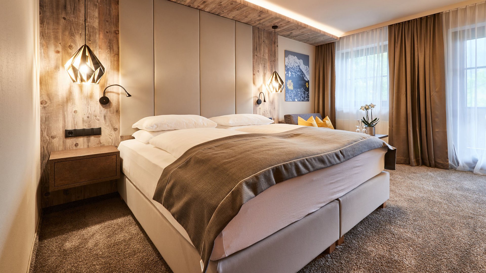 Holidays at the Postwirt: more than just in “a” hotel in Soll. Modern bedroom with double bed, wooden wall, and warm lighting