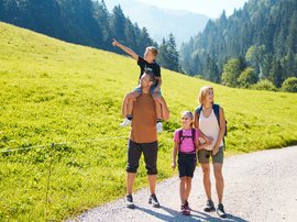Hotel in Söll: the Postwirt Family hiking on a mountain trail on a sunny day