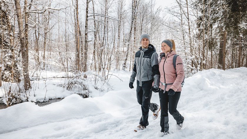 Auszeit zu zweit Paar wandert im Schnee bei winterlichem Waldspaziergang