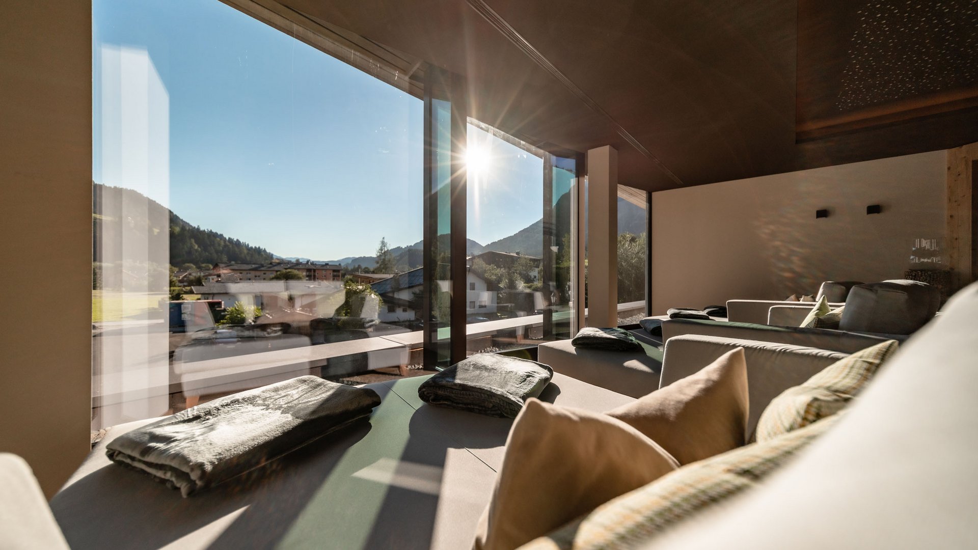 Wellness and spa hotel in Soll Sunlight shining through large windows into a modern, bright living room with seating