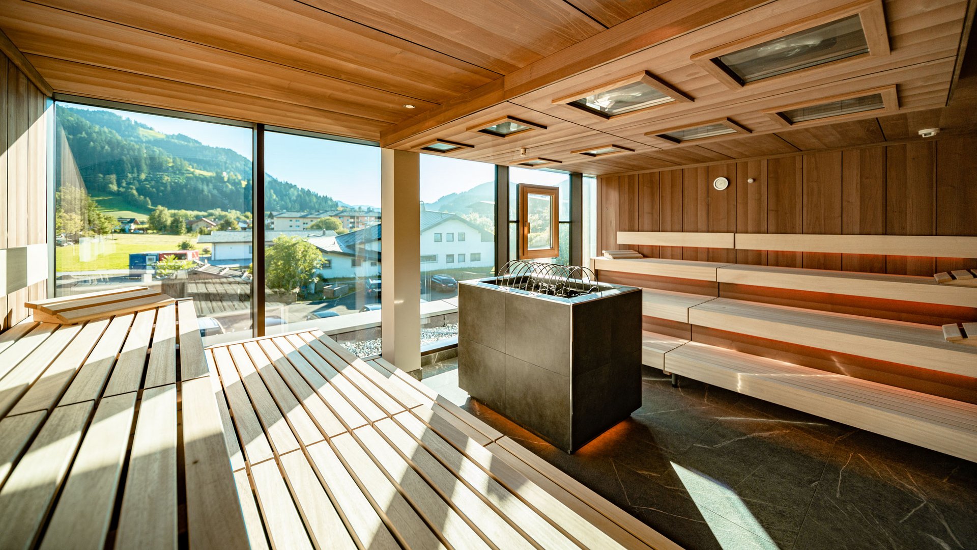 Wellness and spa hotel in Soll Modern sauna interior with wooden panels and mountain view through large windows