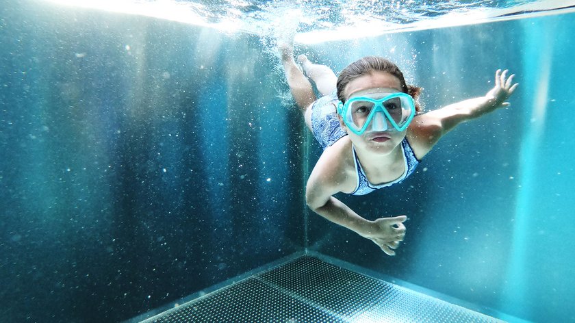 Ihr Familienurlaub in Söll Kind schwimmt unter Wasser in einem Pool mit Taucherbrille