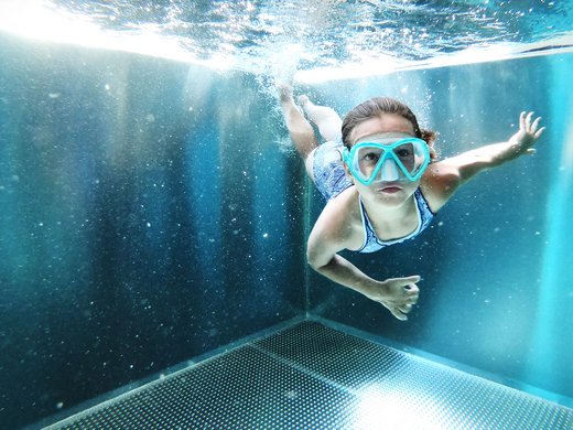 Holidays at the Postwirt: more than just in “a” hotel in Soll. Child swimming underwater in a pool wearing a diving mask