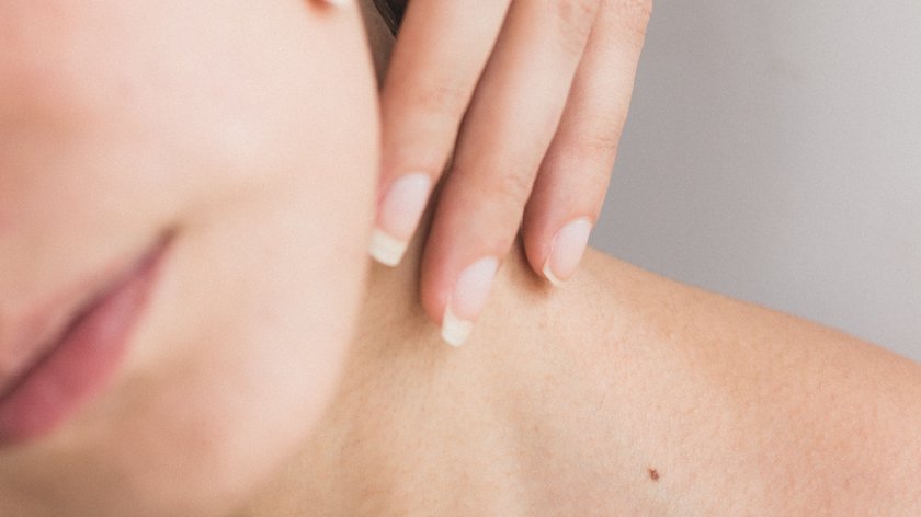 Manuelle Lymphdrainage: Entspannung für Körper und Geist Nahaufnahme von Frau mit Hand am Hals und sichtbaren Muttermalen