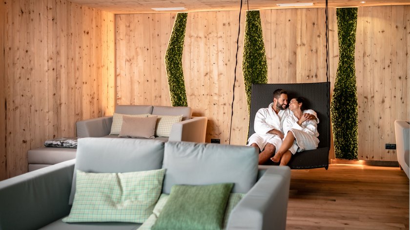 Ein Platz für Verliebte Paar in Bademänteln entspannt auf Liege in modernem Holz- und Moos-Spa-Raum