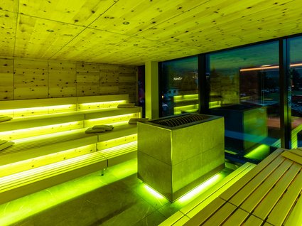 Moderne Sauna mit Panoramablick Modern sauna with yellow lighting and wooden interior in the evening